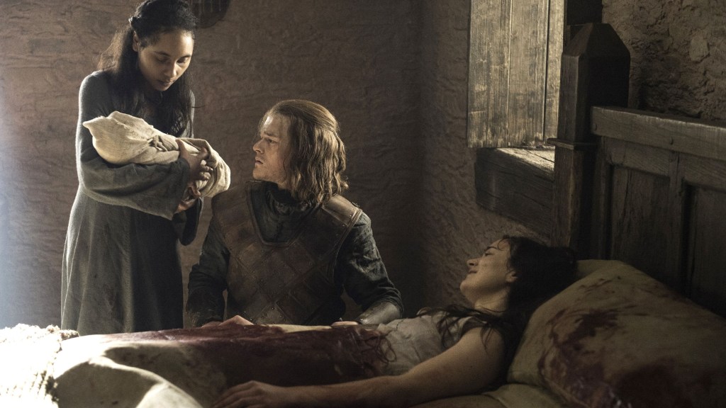 A midwife handing Ned Stark baby Jon Snow, with Lyanna Stark in bed next to them, in Game of Thrones